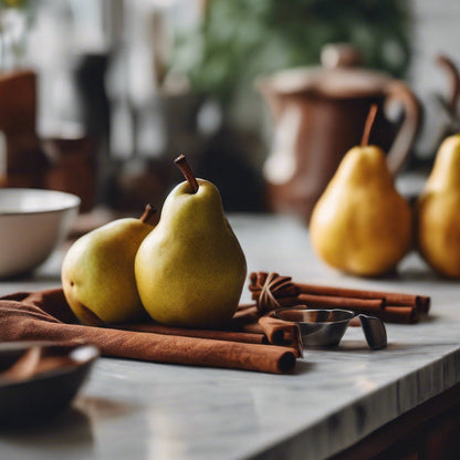 Pears on a kitchen counter with cinnamon sticks and a blurred background