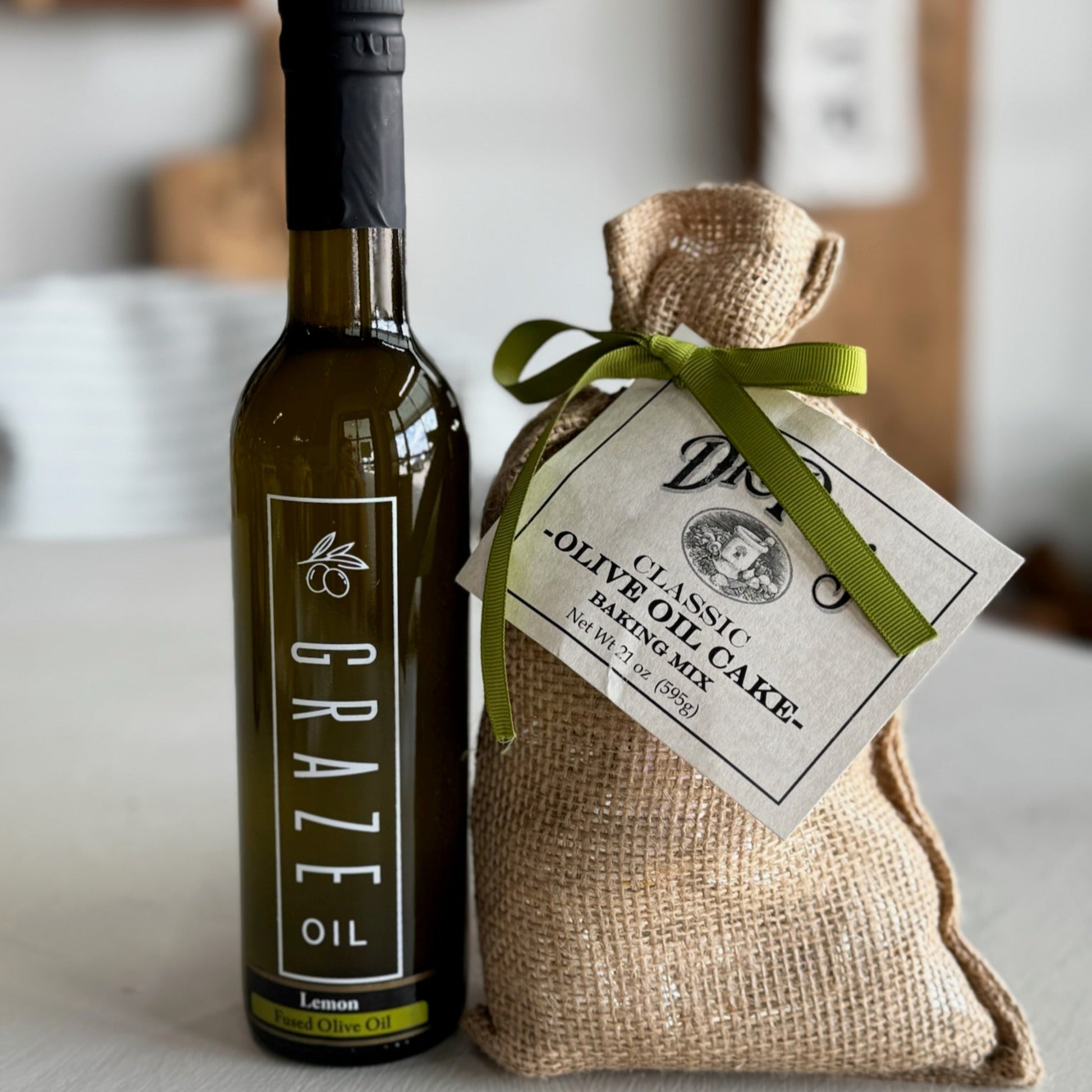 Bottle of olive oil and a bag of olive oil cake on a white surface