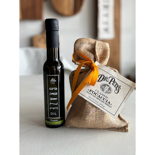 Bottle of Graze Oil with a burlap bag and tag on a light surface.