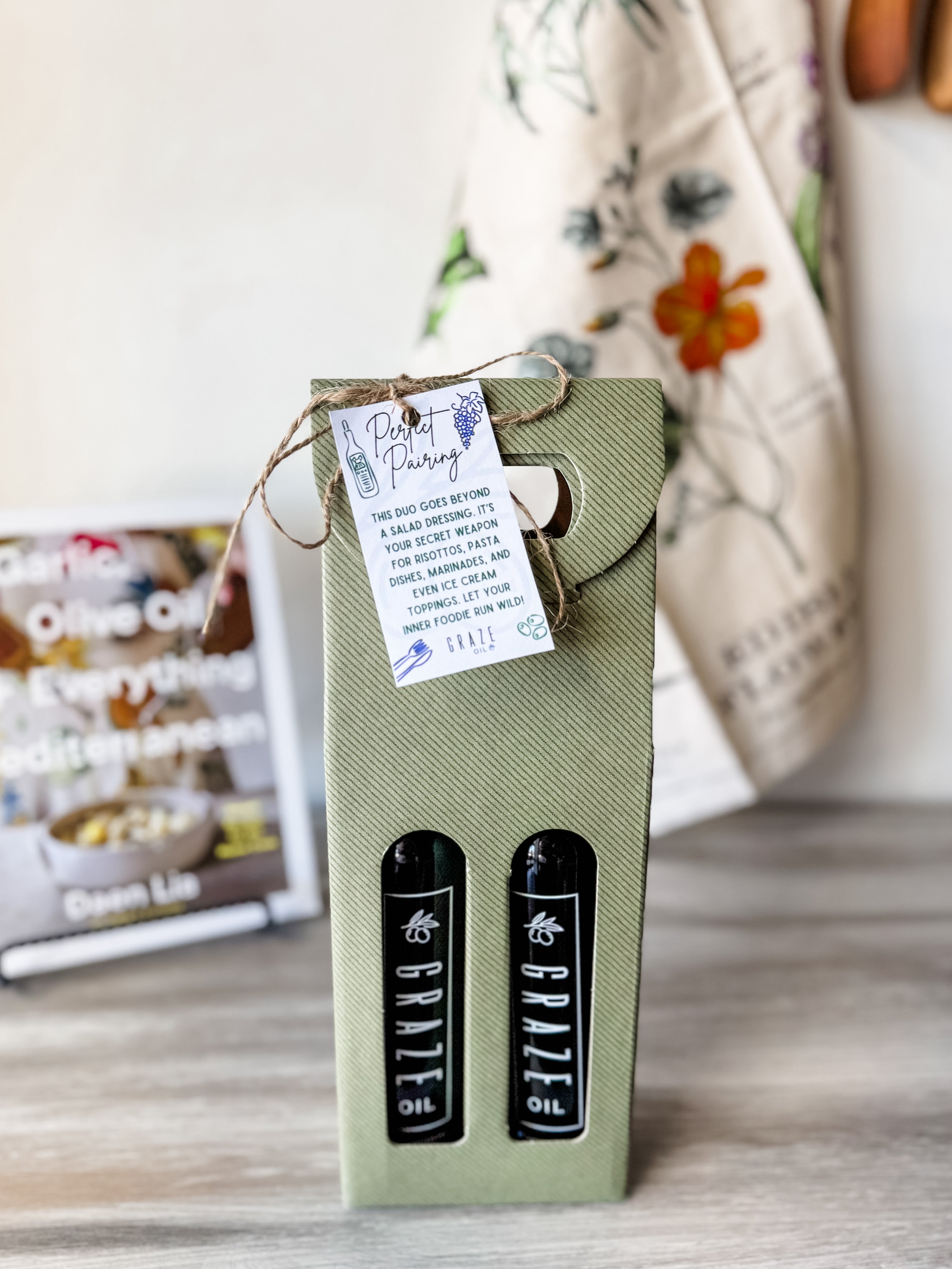 GRAZE OIL Green box with black labels and a tag on a wooden surface