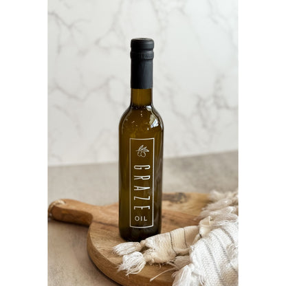 Bottle of Graze oil on a wooden board with a neutral background