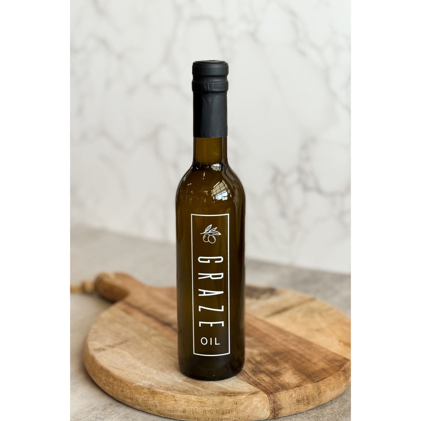Bottle of Graze Oil on a wooden board with a neutral background