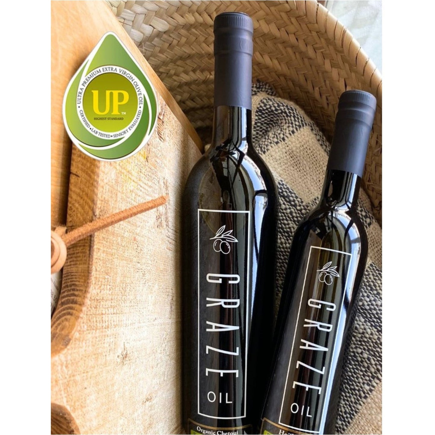 Two bottles of ultra premium Graze Oil with a woven basket background
