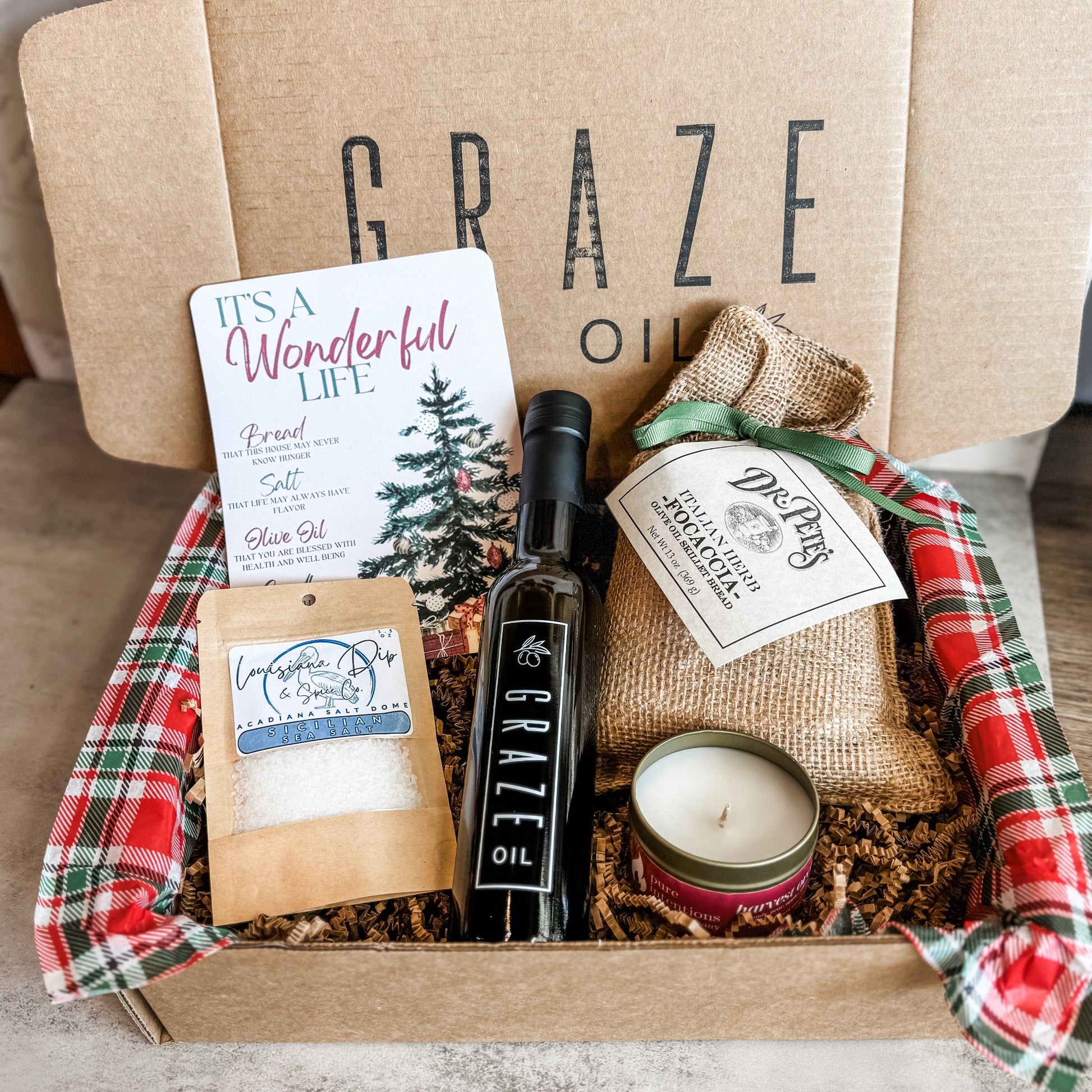 Graze Oil Gift box with various items including a Graze Oil bottle, bread mix in burlap bag with bow, candle, salt 