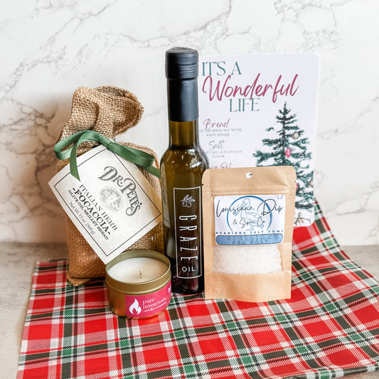 Gift set collection of items items including a Graze Oil bottle, bread mix in burlap bag with bow, candle, salt 