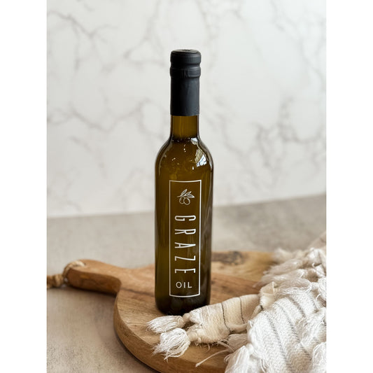 Bottle of Graze oil on a wooden board with a neutral background